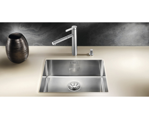 Évier en acier inoxydable avec robinet et distributeur de savon sur un plan de travail