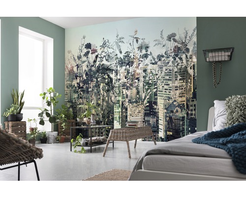 Chambre lumineuse avec un papier peint photo représentant un paysage urbain avec des éléments floraux, complété par des plantes et des meubles clairs.