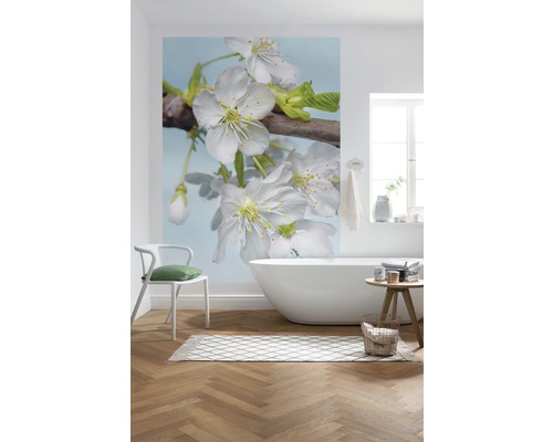 Badezimmer mit Fototapete mit Blütenmotiv, Badewanne und Holzfußboden.