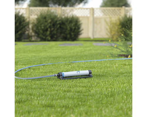 Gartensprenger mit Schlauch auf Rasen