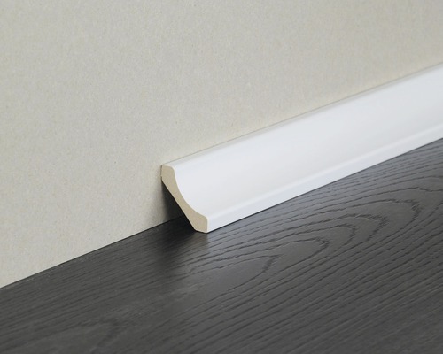 Weisse Fussleiste an einer Wand und einem dunklen Holzboden
