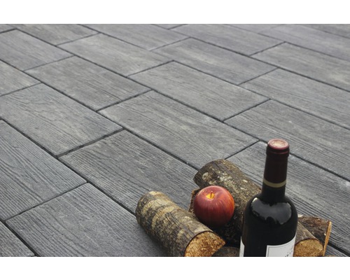 Dalles de terrasse aspect bois avec bouteille de vin, pomme et bûches