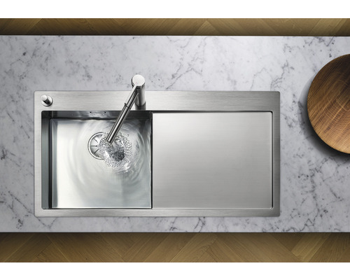 Évier en acier inoxydable avec égouttoir et robinet sur un plan de travail en marbre