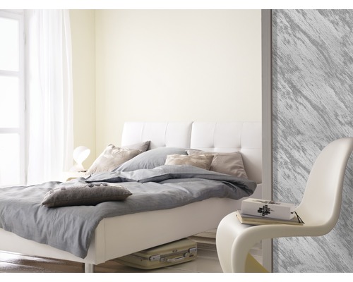Helles Schlafzimmer mit Bett, Kissen, Decke und Stuhl