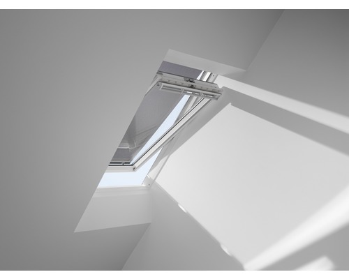Fenêtre de toit ouverte avec protection solaire dans une pièce blanche