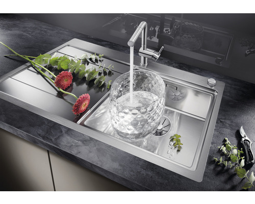 Spültisch aus Edelstahl mit Armatur und Blumen