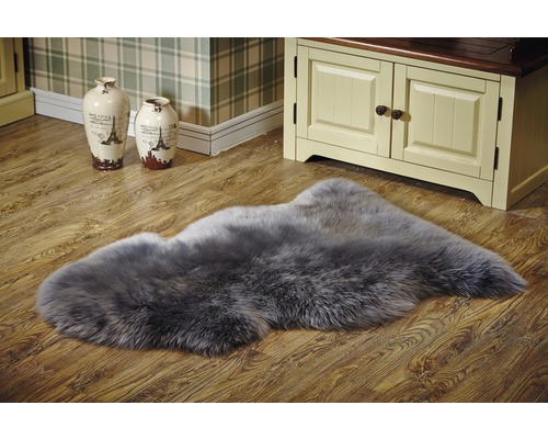 Tapis en peau de mouton gris sur plancher en bois