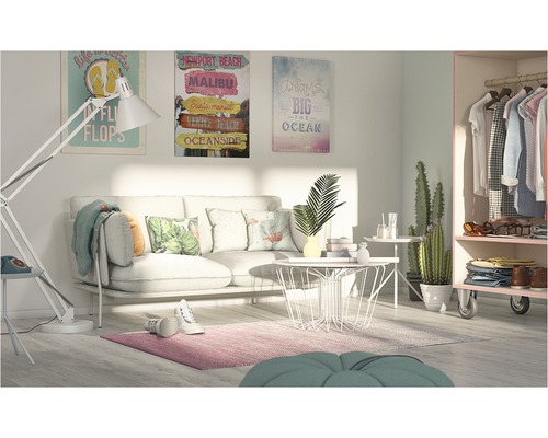 Salon avec canapé, table basse, lampadaire, tapis, décorations, tableaux et armoire.