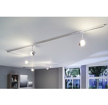 Plafonnier avec système de rails et lampes rondes dans un salon.