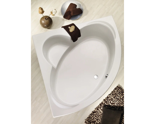 Baignoire d''angle dans salle de bain avec serviettes et tapis de bain