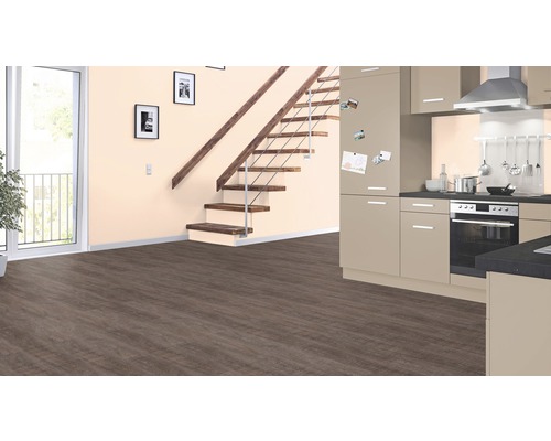 Salon avec escalier, porte, kitchenette et sol stratifié.