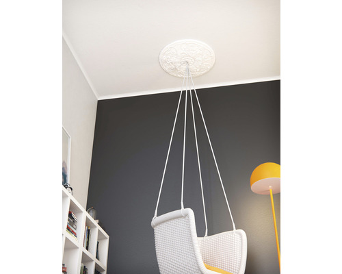 Fauteuil suspendu sur rosace de plafond dans une pièce