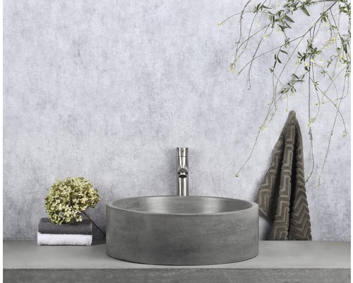 Scène de salle de bains avec vasque à poser ronde, robinetterie et serviette