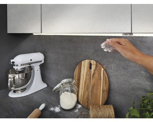 Küchenszene mit Unterbauleuchte, Küchenmaschine, Schneidebrett und Zutaten