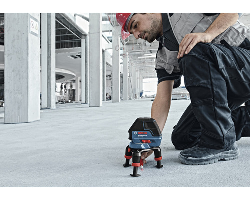 Bauarbeiter mit Bosch Professional Linienlaser zur Ausrichtung auf einer Baustelle