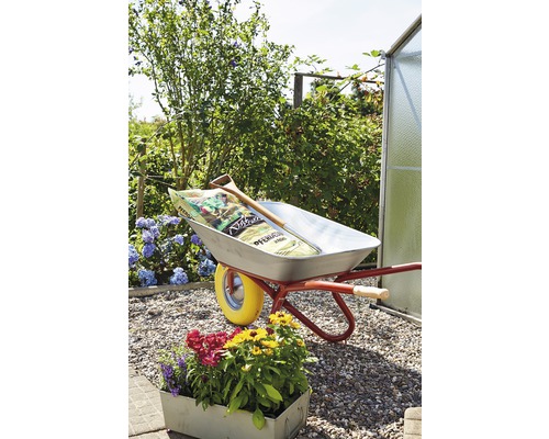 Scène de jardin avec brouette, terreau et plantoir