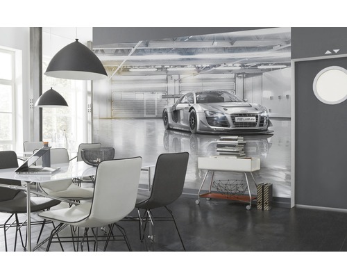 Espace de vie avec papier peint photo représentant une voiture de course dans un garage, table à manger et suspensions