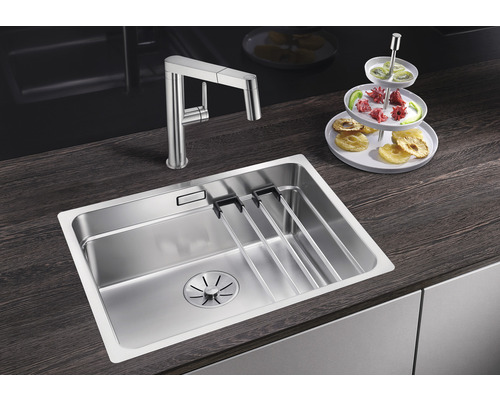 Évier en acier inoxydable avec égouttoir et robinet de cuisine sur un plan de travail foncé