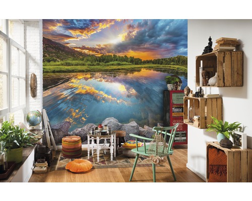 Salon avec papier peint photo d''un lac au coucher du soleil, décoré de divers meubles et accessoires.