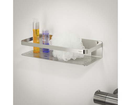 Étagère de douche angulaire en acier inoxydable avec produits de soin et éponge de bain sur un mur