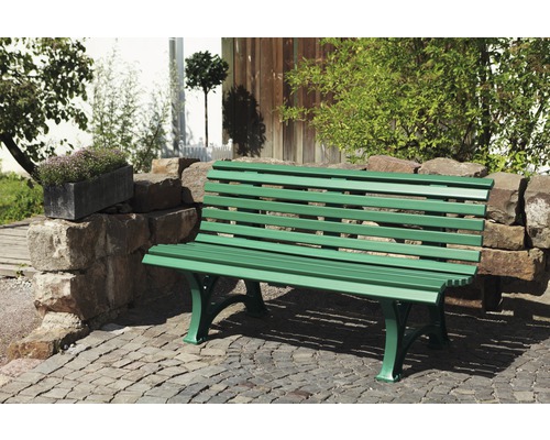 Banc de jardin vert en métal sur sol pavé
