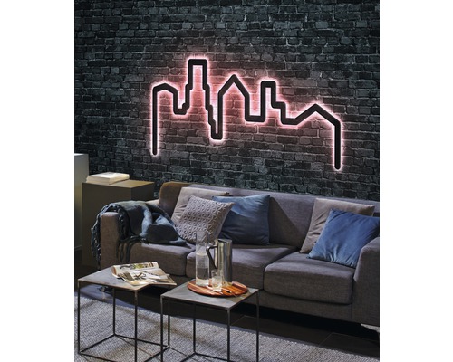 Wohnzimmer mit Sofa und einer Wanddekoration in Form einer Skyline mit Beleuchtung