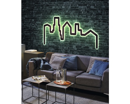 Wohnzimmer mit Sofa, Couchtischen und beleuchtetem Wandbild Skyline