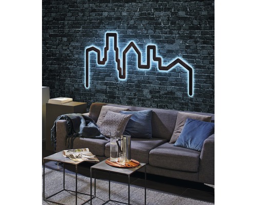 Wohnzimmer mit Sofa und beleuchteter Skyline Wanddekoration