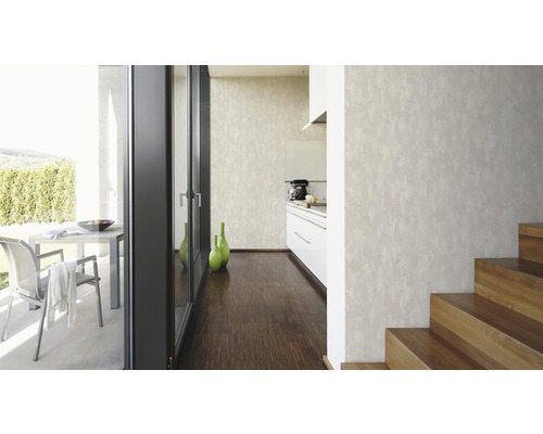 Pièce lumineuse avec papier peint structuré, escalier et coin cuisine