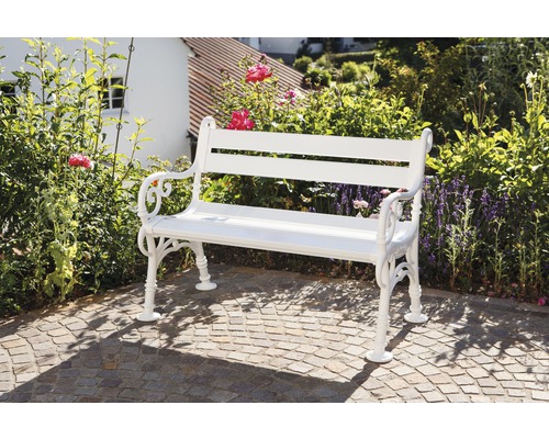 Banc de jardin blanc en métal devant un jardin