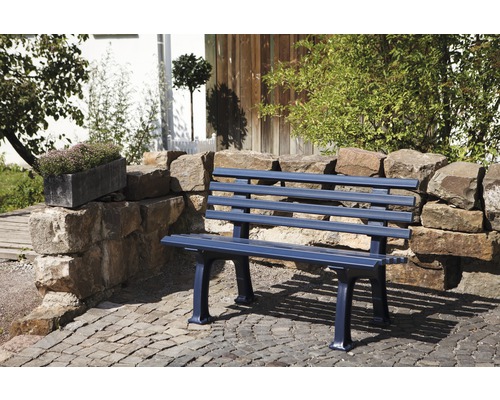 Banc de jardin devant un mur de pierre