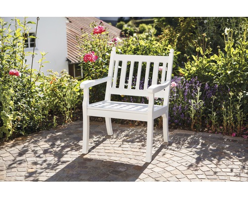 Chaise de jardin en bois devant un jardin fleuri