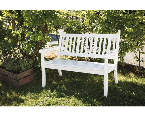 Banc de jardin blanc en bois à côté d''une plante sur une pelouse