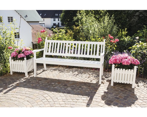 Scène de jardin avec un banc de jardin blanc en bois et deux jardinières avec des plantes