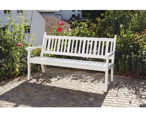 Banc de jardin en bois devant maison et jardin