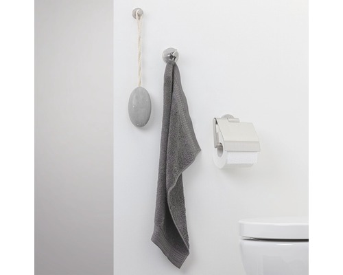 Mur de salle de bain avec serviette, savon et distributeur de papier toilette