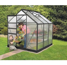 Serre avec porte ouverte, femme et enfant dans le jardin