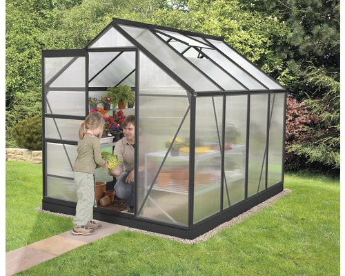 Serre avec une personne et un enfant plantant des plantes