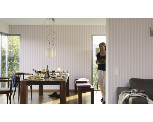 Salle à manger avec table, chaises, bancs et papier peint rayé