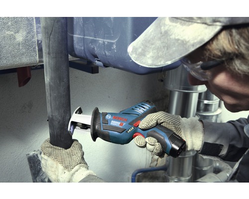 Artisan coupant un tuyau avec une scie sabre Bosch