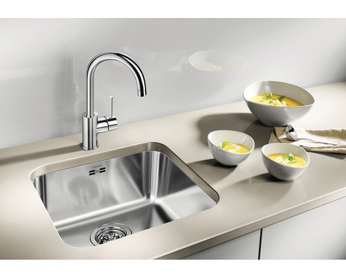 Edelstahlspüle mit Armatur und drei Schalen Suppe auf einer Arbeitsplatte