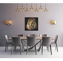 Salle à manger avec table, chaises, appliques murales, suspensions et tableau représentant un lion