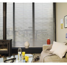 Wohnzimmer mit Fensterjalousien, Ofen und Sofa