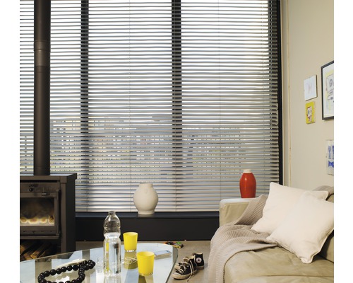 Wohnzimmer mit Fensterjalousien, Ofen und Sofa