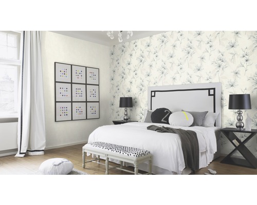 Schlafzimmer mit floraler Tapete, Bett, Bank und Dekorationsgegenständen.