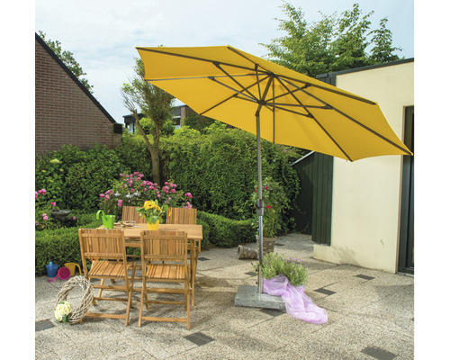 Gelber Gartenschirm über Holztisch und Stühlen im Garten