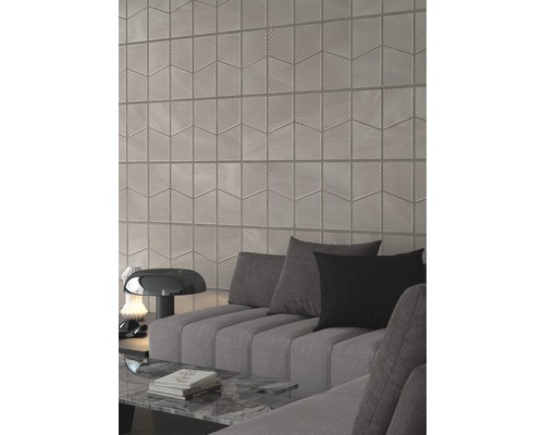 Wohnzimmer mit Wandfliesen in geometrischem Design und grauem Sofa