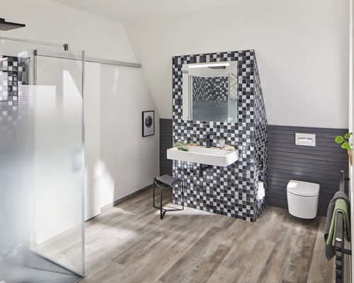 Salle de bain moderne avec douche, lavabo, miroir et toilettes sous un toit mansardé