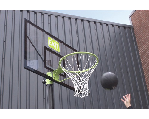 Panier de basket-ball avec ballon et filet devant un mur