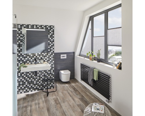 Salle de bain lumineuse avec lavabo, toilettes, radiateur et fenêtre